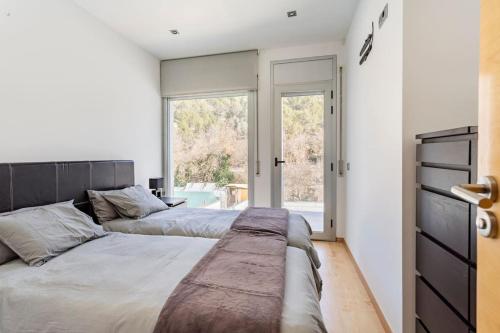 two beds in a bedroom with a window at Exclusiva Villa de Lujo con piscina in Canyelles