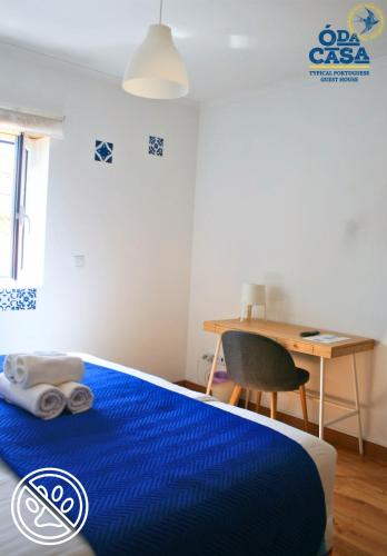 a bedroom with a blue bed and a desk at Ó da Casa in Peniche