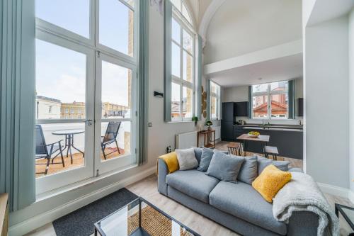a living room with a couch and large windows at The Old Town Hall - 12 in Staines