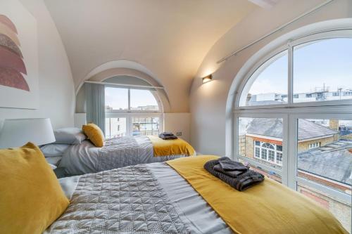 2 camas en una habitación con ventana grande en The Old Town Hall - 12 en Staines