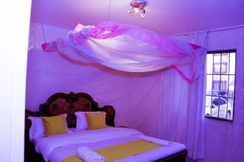 a purple bedroom with a bed with a canopy at Dolly Apartments in Nairobi