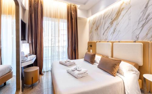 a hotel room with a bed with towels on it at Hotel Feldberg in Riccione