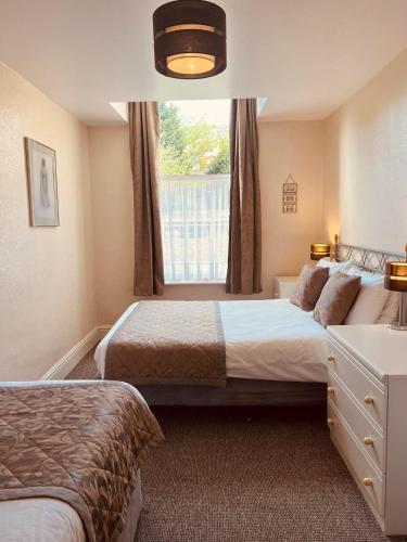 a bedroom with two beds and a window at Brialene Holiday Flats in Scarborough
