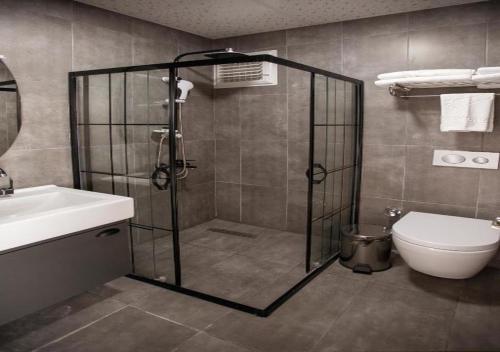 y baño con ducha, aseo y lavamanos. en MED Airport Hotel, en Arnavutköy