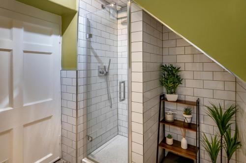 a bathroom with a walk in shower with plants at Garden maisonette in Bath city centre in Bath