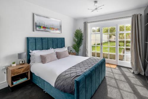 a bedroom with a blue bed and a window at Garden maisonette in Bath city centre in Bath