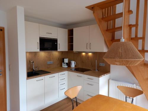 een keuken met witte kasten en een trap bij Nordseemole in Horumersiel