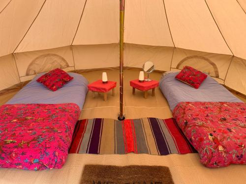 two beds in a tent with two candles on them at Fred's Yurts at Hay Festival in Hay-on-Wye