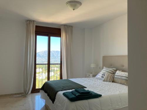1 dormitorio con cama y ventana grande en Socrates Holiday Rental, La Mairena - El Soto Golf Club FREE PADEL GYM TENNIS & GOLF en Ojén
