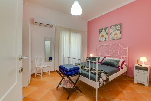 a pink bedroom with a bed and a desk at Namuri Rooms in Sciacca