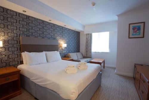 Una habitación de hotel con una cama con dos toallas. en Tong Park Hotel, en Bradford
