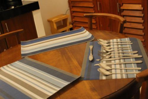 a wooden table with plates and napkins on it at Cottage 23 in Kurunegala