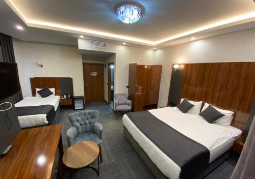 Habitación de hotel con 2 camas y mesa en MED Airport Hotel, en Arnavutköy