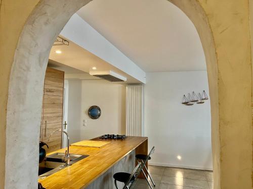 an archway in a kitchen with a sink and a counter at Le Cours Ladauge in La Rochelle