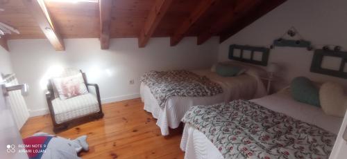 een slaapkamer met 2 bedden en een stoel in een kamer bij Lezegorria in Urzainqui