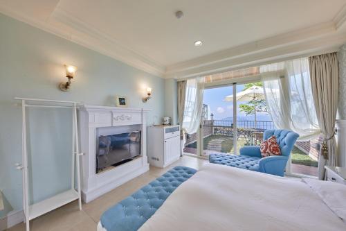 a bedroom with a bed and a fireplace and a balcony at Ming Ging Farm in Ren'ai