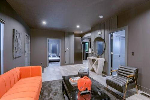 a living room with an orange couch and a chair at Elegant Black Modern in Lincoln