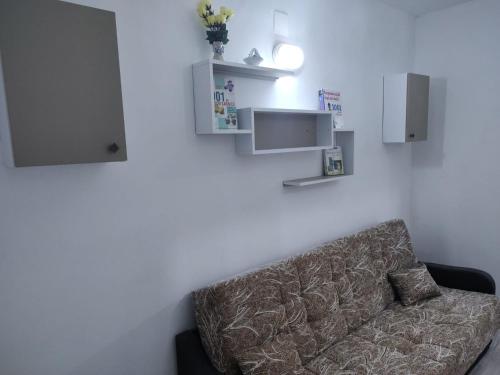 a couch in a living room with white walls at Family Rooms Hunedoara in Hunedoara