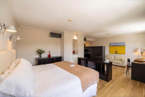 a bedroom with a large bed and a living room at AWA Boutique + Design Hotel in Punta del Este