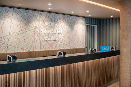 a lobby of a hotel with a sign on the wall at Hampton By Hilton London City in London