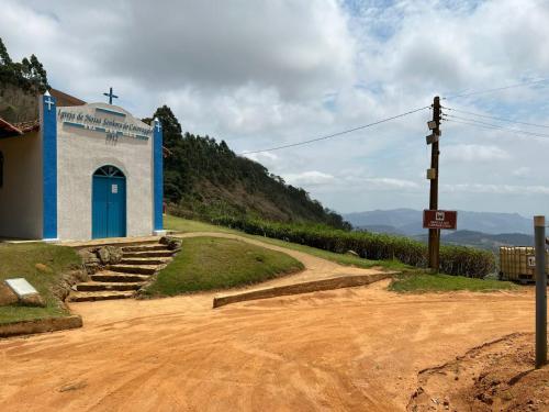 a small blue and white church on a dirt road at Chalés Villa Caravaggio in Santa Teresa