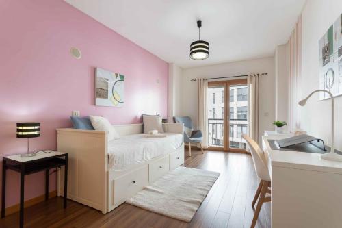 um quarto com uma cama com uma parede rosa em Modern & Elegant 2 bedroom in Amadora by GT House em Amadora