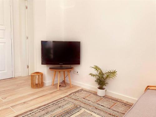 a flat screen tv sitting on a wall in a living room at Cozy apartment with private courtyard in Barcarena