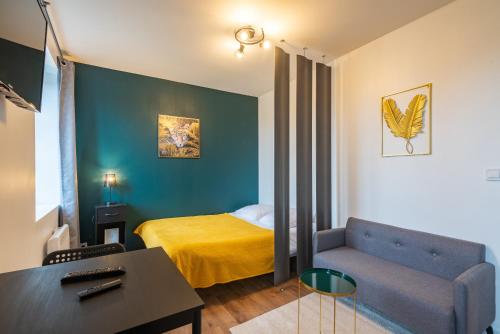 mały pokój z łóżkiem i kanapą w obiekcie Bistrot 8 w mieście Nazelles