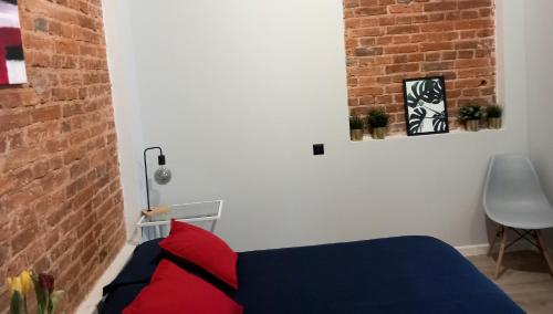 a bedroom with a blue bed and a brick wall at Hola Apartamenty Legionow in Łódź