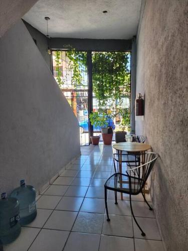 a room with a table and chairs on a tiled floor at Small studio APT 5min to DT! in Zihuatanejo