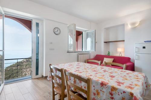 1 dormitorio con 1 cama y balcón con reloj en Casa mare montaretto 2, en Bonassola