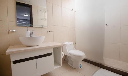 Baño blanco con lavabo y aseo en Bellini I 2, 2 habitaciones, Puerto Santa Ana, Guayaquil, en Guayaquil