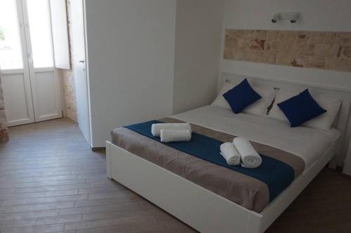 Un dormitorio con una cama con almohadas azules y blancas. en Il Sogno di SaZa, en Castellana Grotte