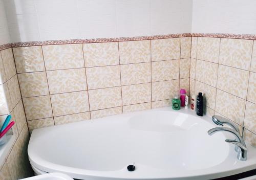 La salle de bains est pourvue de toilettes blanches et d'un lavabo. dans l'établissement Vila House in the city center of Ukmerge, à Ukmergė