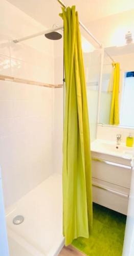 La salle de bains est pourvue d'une douche avec rideau de douche jaune. dans l'établissement Apartment Green Apple Cap Esterel, à Saint-Raphaël