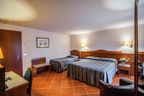 a hotel room with two beds and a table at Hotel Martelli in Florence