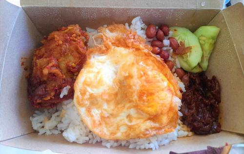una scatola di cibo con riso, un uovo fritto e fagioli di The Hill a Kampong Sum Sum