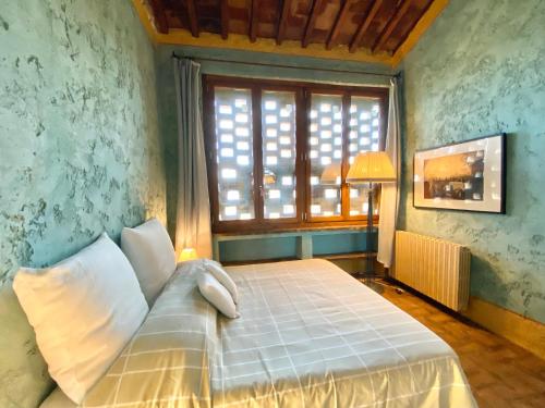 a bedroom with a bed with a large window at Berenice in Chianti - Authentic Tuscan Country House in Bagno a Ripoli