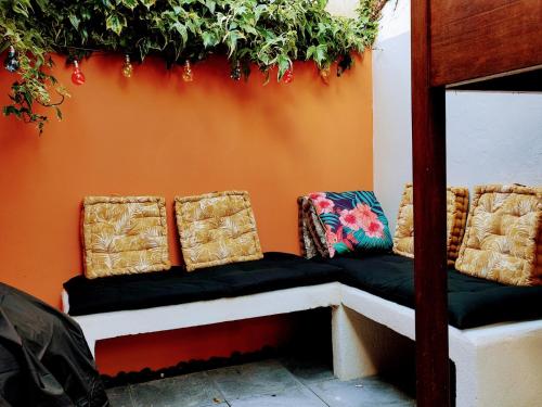 un banc avec des oreillers assis contre un mur dans l'établissement Loueurdappart - Maison Calme Entre Mer et Commerces Tout à Pied, à La Baule