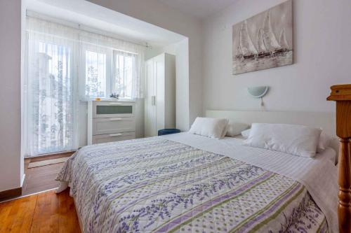 um quarto com uma cama grande e uma janela em Apartment in Crikvenica 14216 em Crikvenica