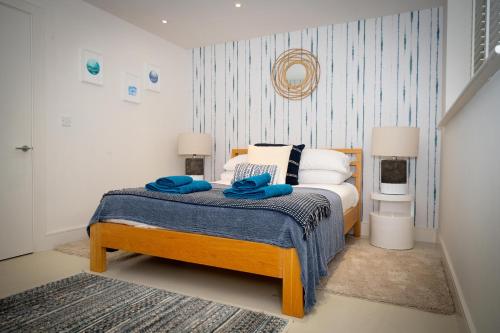 ein Schlafzimmer mit einem Bett mit blauen Handtüchern darauf in der Unterkunft Wild Sands Next to Beach ✩ Cinema ✩ Living Roof ✩ Games Room in Camber