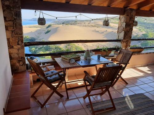 un tavolo e sedie su un balcone con vista sulla spiaggia di Casa Ester a Torre Dei Corsari