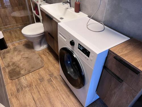 a washing machine in a bathroom with a toilet at Przytulne z widokiem in Szczecin