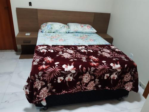 a bed with a brown blanket with flowers on it at CONDÓMINIO BEIRA RIO in Canindé de São Francisco
