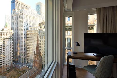 um quarto com uma secretária e uma grande janela com vista em Hotel Indigo NYC Financial District, an IHG Hotel em Nova York