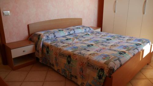 a bedroom with a bed with a quilt on it at Appartamento vista mare Poseidonia in Nebida