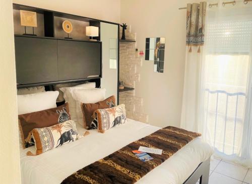a bedroom with a large bed with pillows on it at Hôtel Le Méditerranée in Hyères