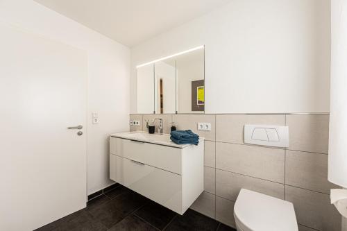 bagno bianco con servizi igienici e lavandino di Ferienwohnung Hoffmann-Schiffer a Bischofswiesen