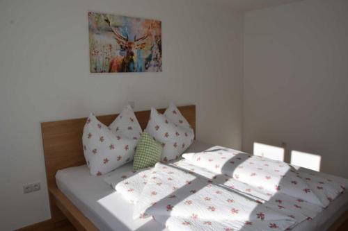 a bed with white sheets and pillows on it at Ferienhus Klus 415 in Mellau