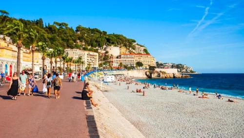 un gruppo di persone su una spiaggia vicino all'oceano di Appartement d'une chambre a Nice a 200 m de la plage avec vue sur la mer terrasse et wifi a Nizza